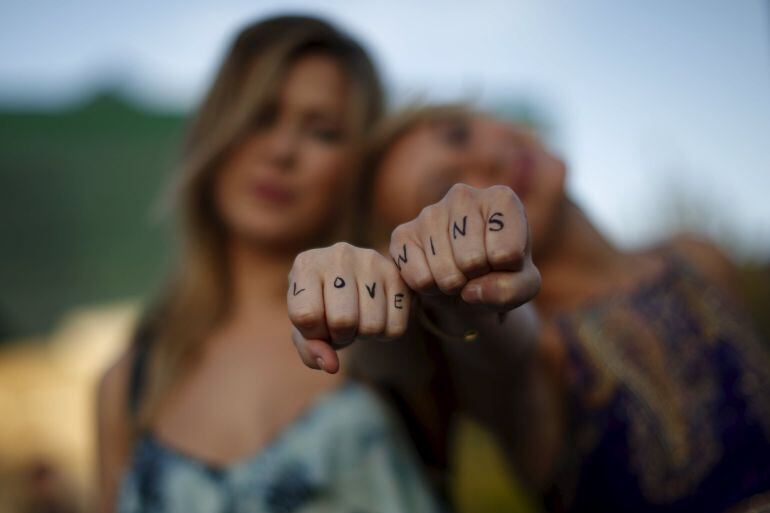 REFILE - CORRECTING POSITION OF CHERILYN WILSON  Cherilyn Wilson, 26, (L) and Chelsea Kane, 26, display their fists, with the message &quot;Love Wins&quot; written on them, as they pose at a celebration rally in West Hollywood, California, United States, June 26, 2