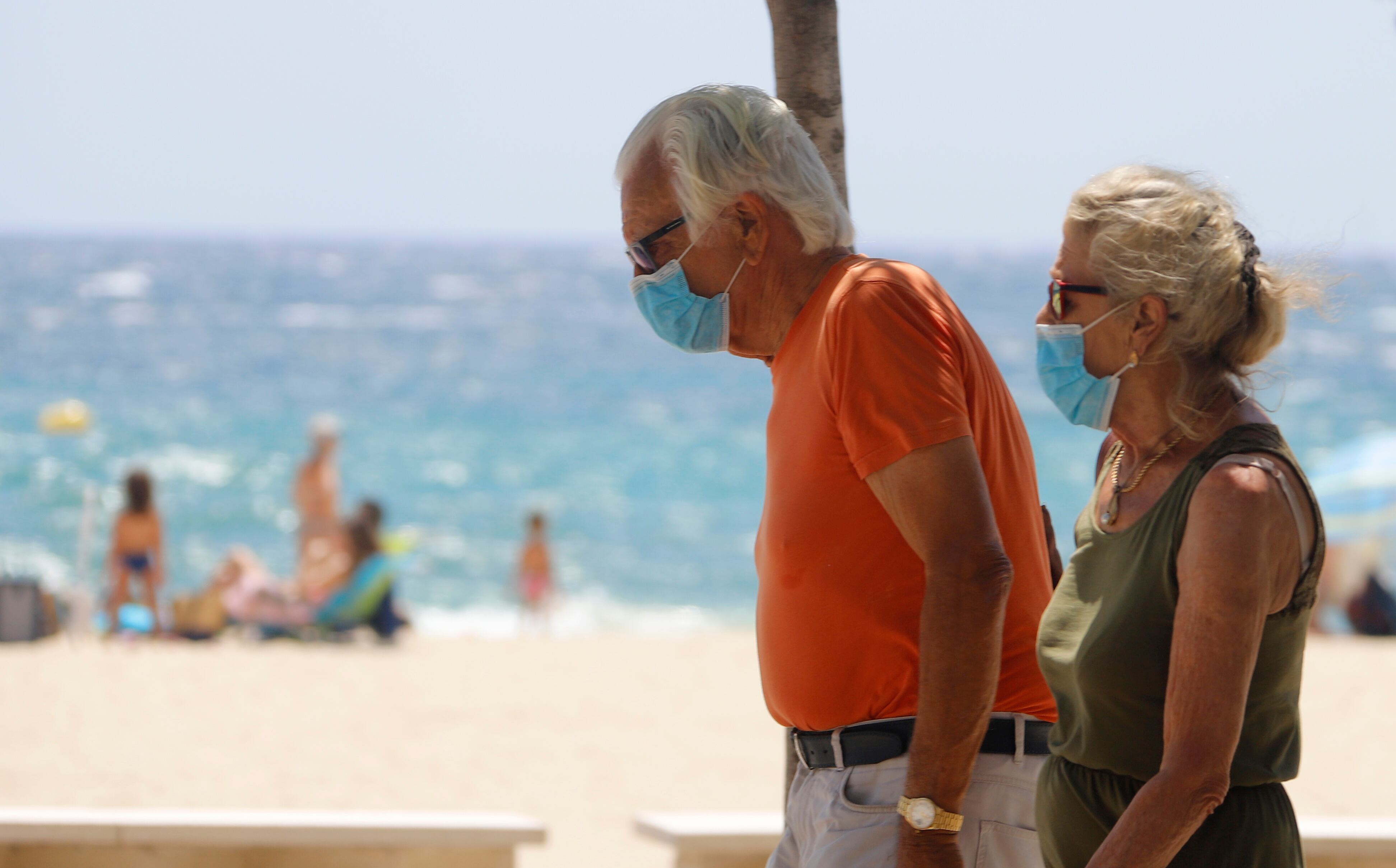 Una pareja pasea por una playa de Mallorca.