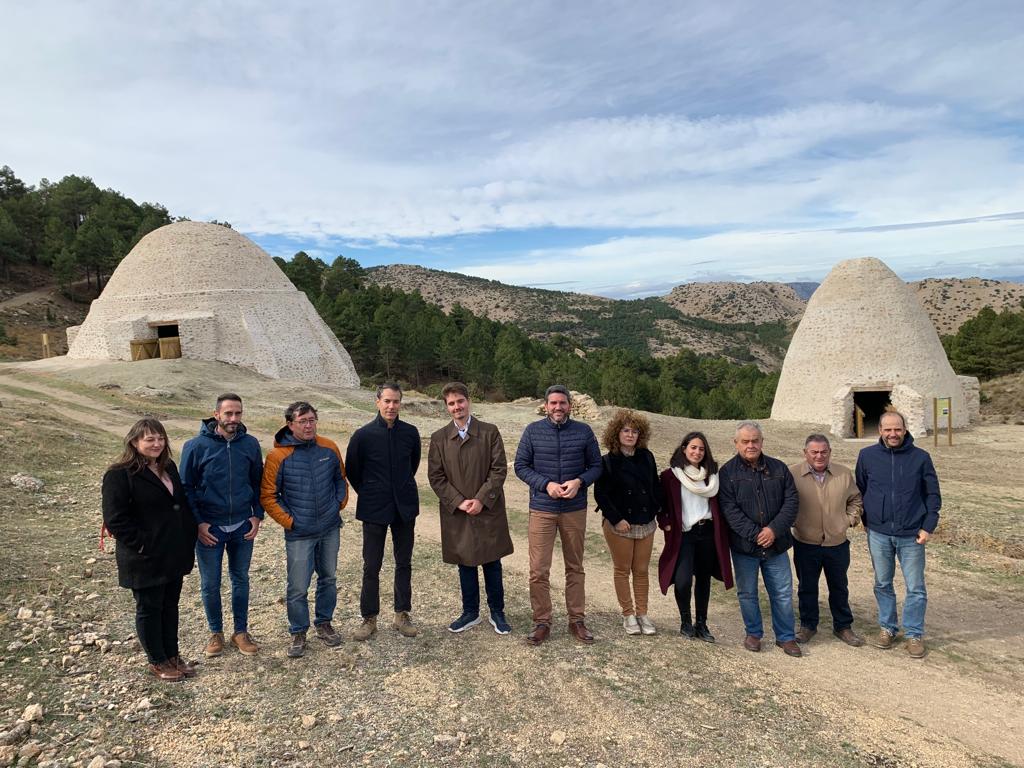 El consejero Antonio Luengo y representantes de instituciones y empresas vinculadas a la restauración, con los dos pozos de la nieve detrás