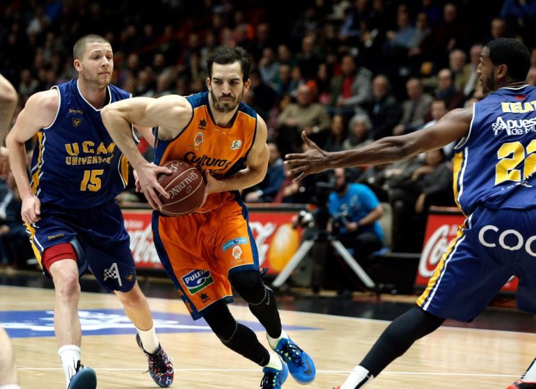 GRA295. VALENCIA, 24/01/2015.- El escolta del Valencia, Pau Ribas (c), controla la pelota ante los estadounidenses Scott Wood (i) y Thomas Kelati (d), del Ucam Murcia, durante el partido correspondiente a la jornada 18º de la Liga ACB de baloncesto disputado hoy en el pabellón La Fuente de San Luis, en Valencia.- EFE/Juan Carlos Cárdenas