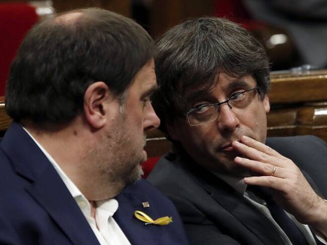 El presidente de la Generalitat, Carles Puigdemont, conversa con el vicepresidente, Oriol Junqueras (i), durante el pleno monográfico celebrado esta tarde para abordar la respuesta a la aplicación del artículo 155 de la Constitución.