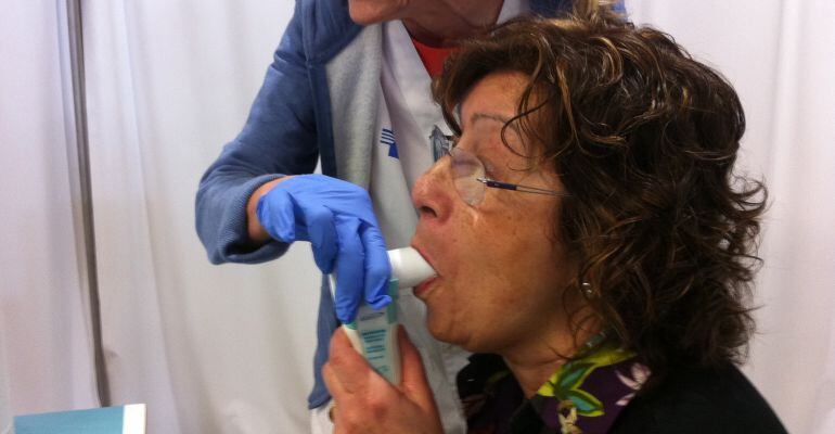 Una pacient fent la prova que mesura la seva capacitat pulmonar al vestíbul de l'Hospital Arnau de Vilanova