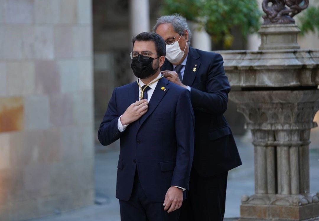 El expresidente Quim Torra pone la medalla de presidente de la Generalitat a Pere Aragonès