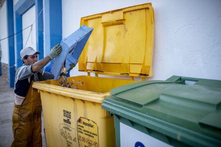 Uno de los pescadores depositando la basura en el contenedor habilitado