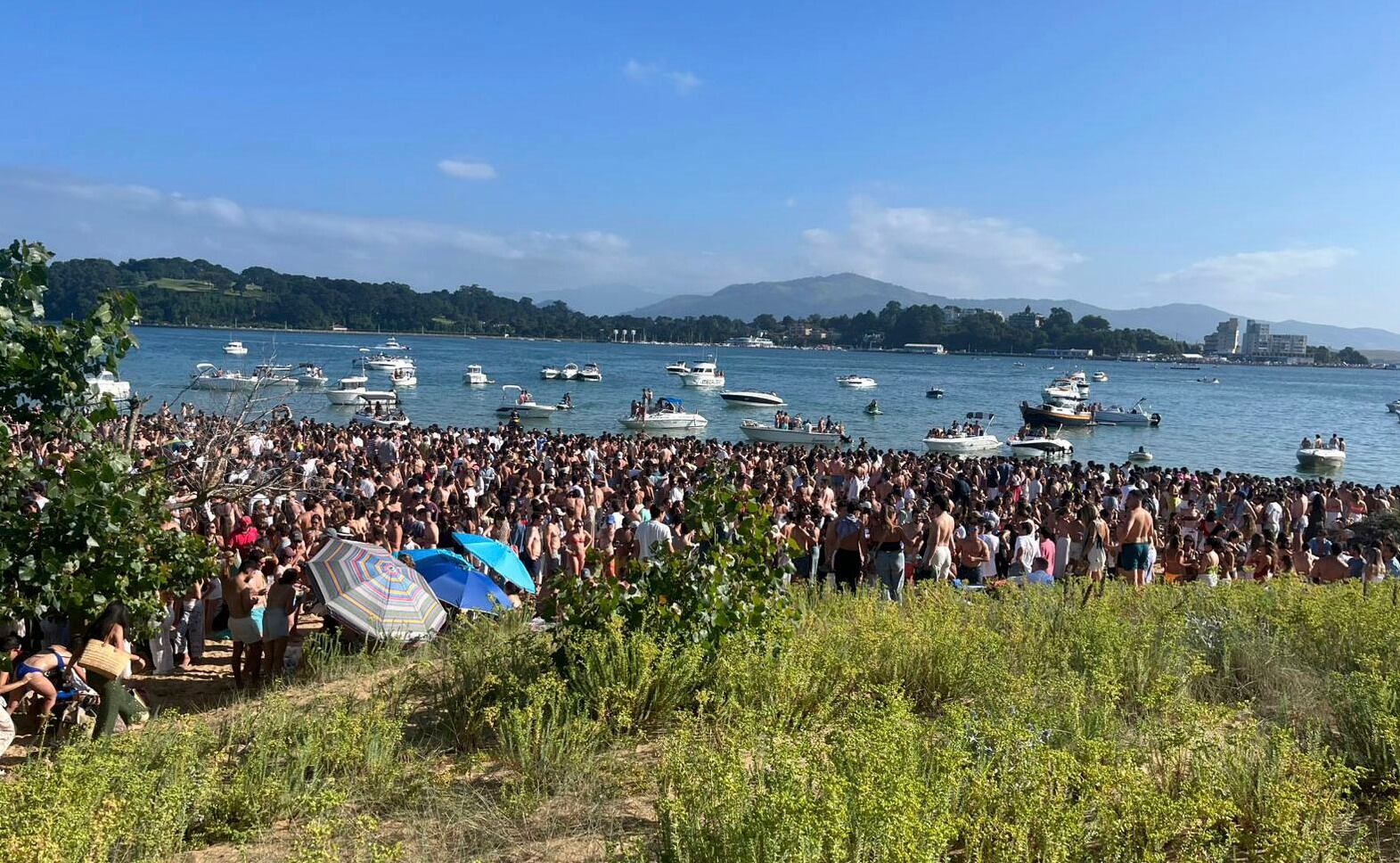 SANTANDER. 26/07/2025.- Imagen de la playa de El Puntal este sábado donde muchos jóvenes que acceden quedan por redes sociales, en una escena que se viene repitiendo varios veranos. EFE/Pablo G. Hermida.
