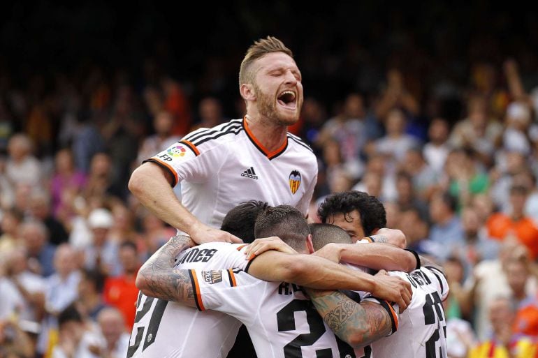 Valencia players celebrate after scoring during the Spanish league football match Valencia CF vs SD Eibar at the Mestalla stadium in Valencia on May 3, 2015.   AFP PHOTO/ JOSE JORDAN