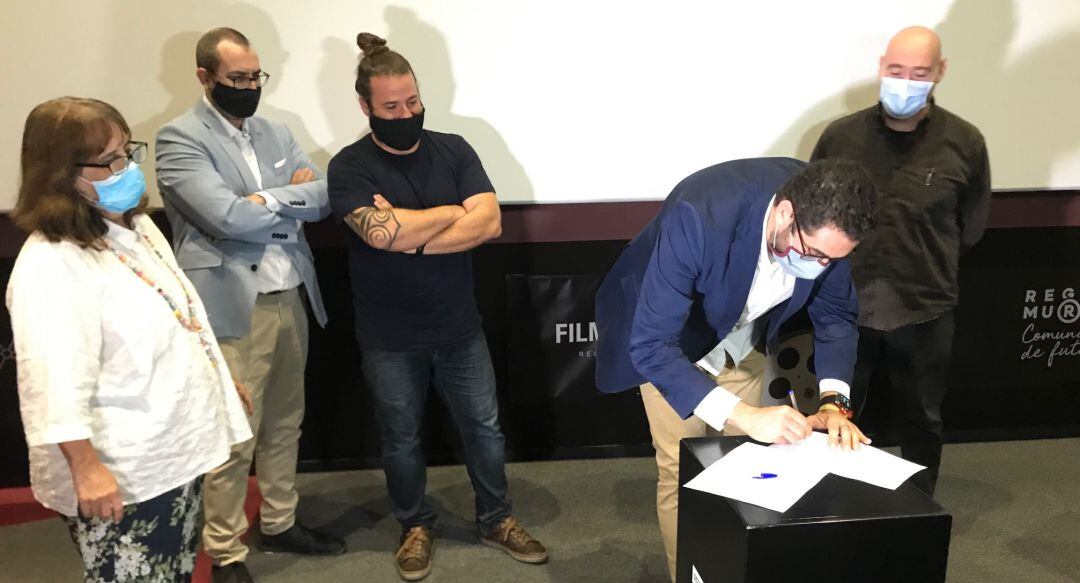 Los representantes de las diversas asociaciones firman el documento de la Unión Audiovisual. De izquierda a derecha, Cecilia Ibáñez, José Sánchez, Alejandro Ríos, Antonio Abril (firmando el documento) y Manuel Reyes