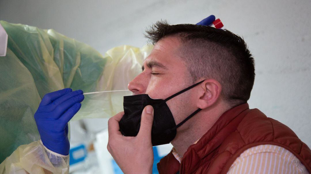 Archivo - Una sanitaria toma muestras a un hombre para realizar una PCR.