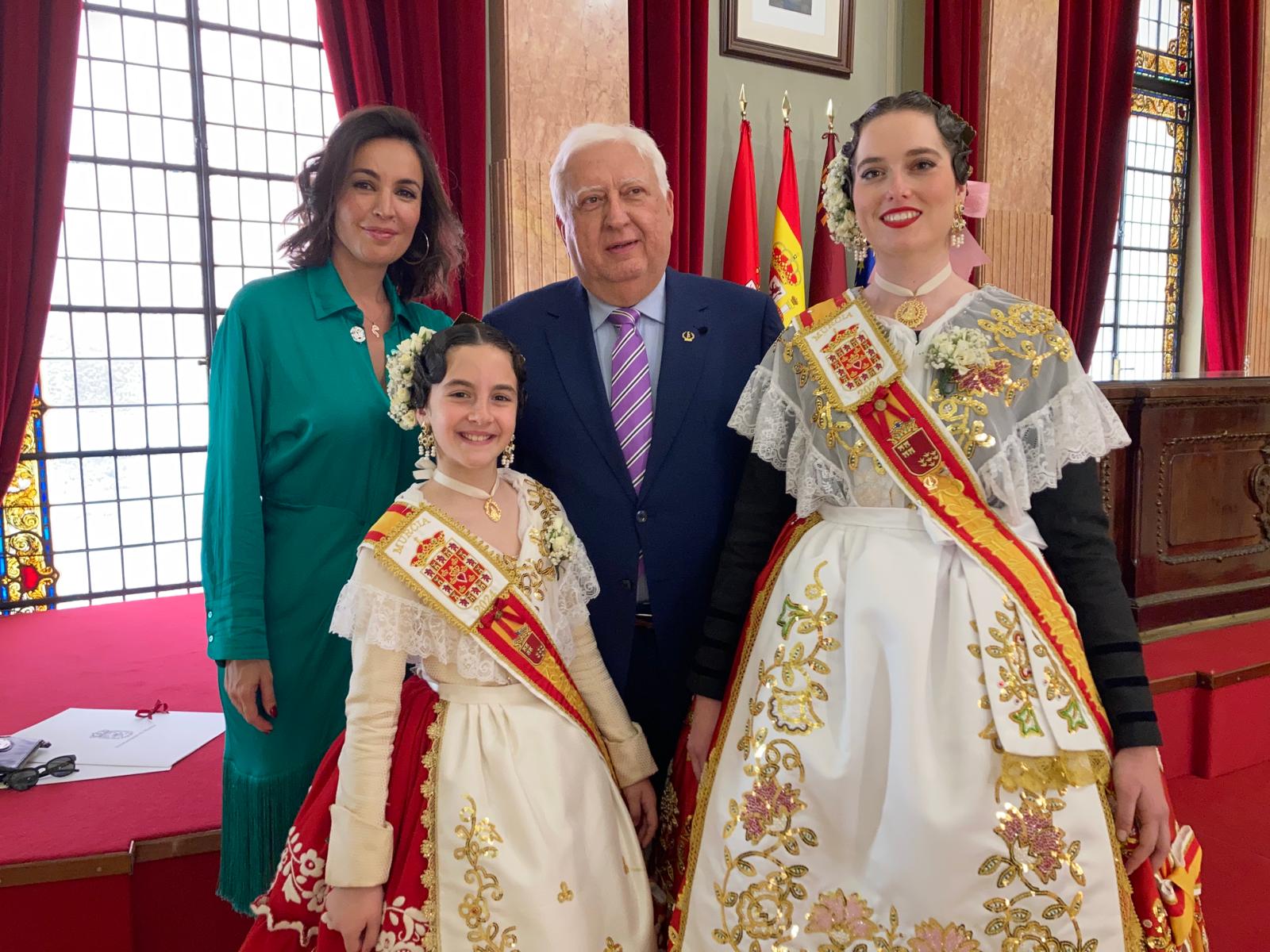 La modelo Mª José Besora (de verde), junto a Juan García, presidente de la Federación de Peñas Huertanas, acompañando a Isabel María García Ortiz, reina de la Huerta 2024 y a Alexia Montemayor Torres, reina de la Huerta infantil, en el Salón de Plenos del Ayto. de Murcia.