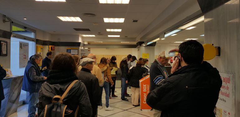 Varias decenas de ciudadanos ejercen su derecho al voto por correo en una oficina de Granada