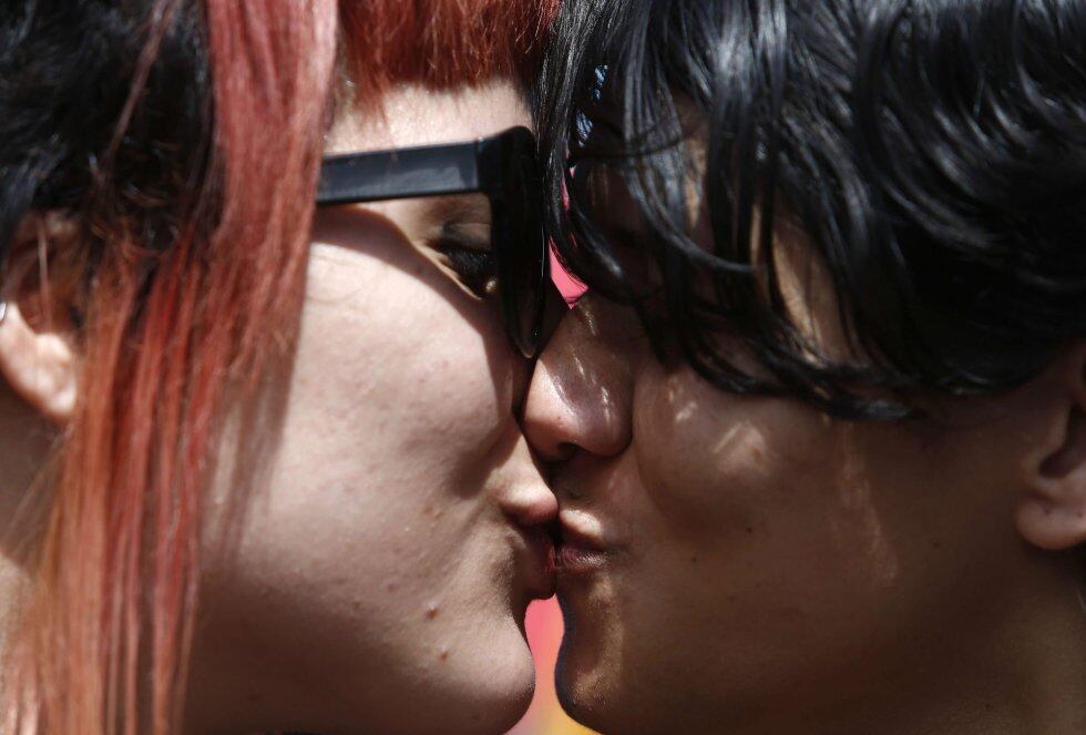 Dos mujeres se besan en el desfile del orgullo de Lesbianas, Gays, Bisexuales y Transexuales (LGBT).