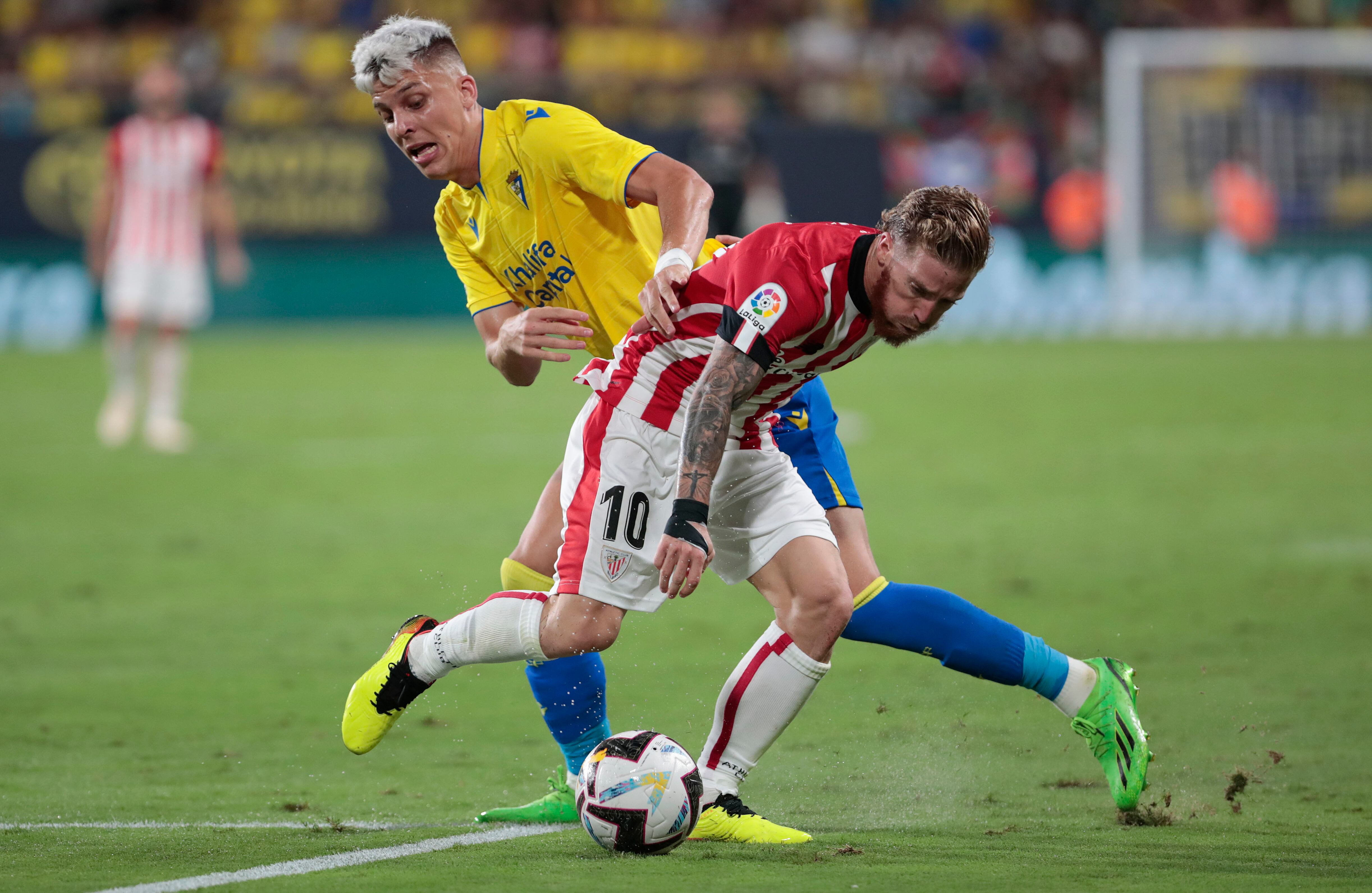 CÁDIZ, 29/08/2022.- El centrocampista del Athletic Iker Muniain (d) protege un balón ante Iván Alejo, del Cádiz, durante el partido de la tercera jornada de Liga en Primera División que enfrenta al Cádiz CF y al Athletic Club de Bilbao hoy lunes en el estadio Nuevo Mirandilla. EFE/Román Ríos.
