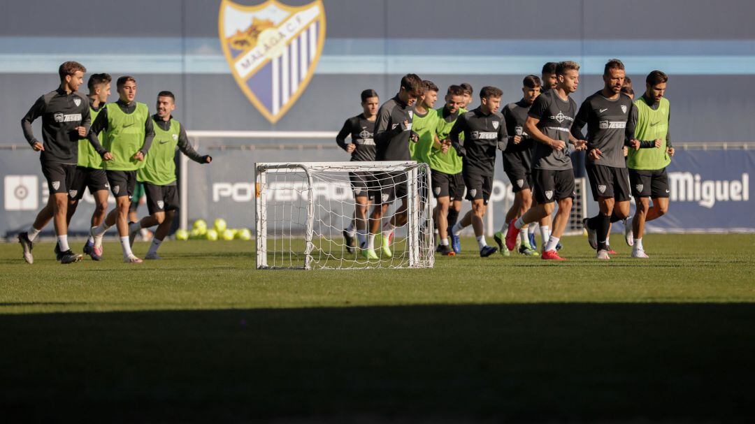 Los jugadores del Málaga corren sobre el césped del anexo