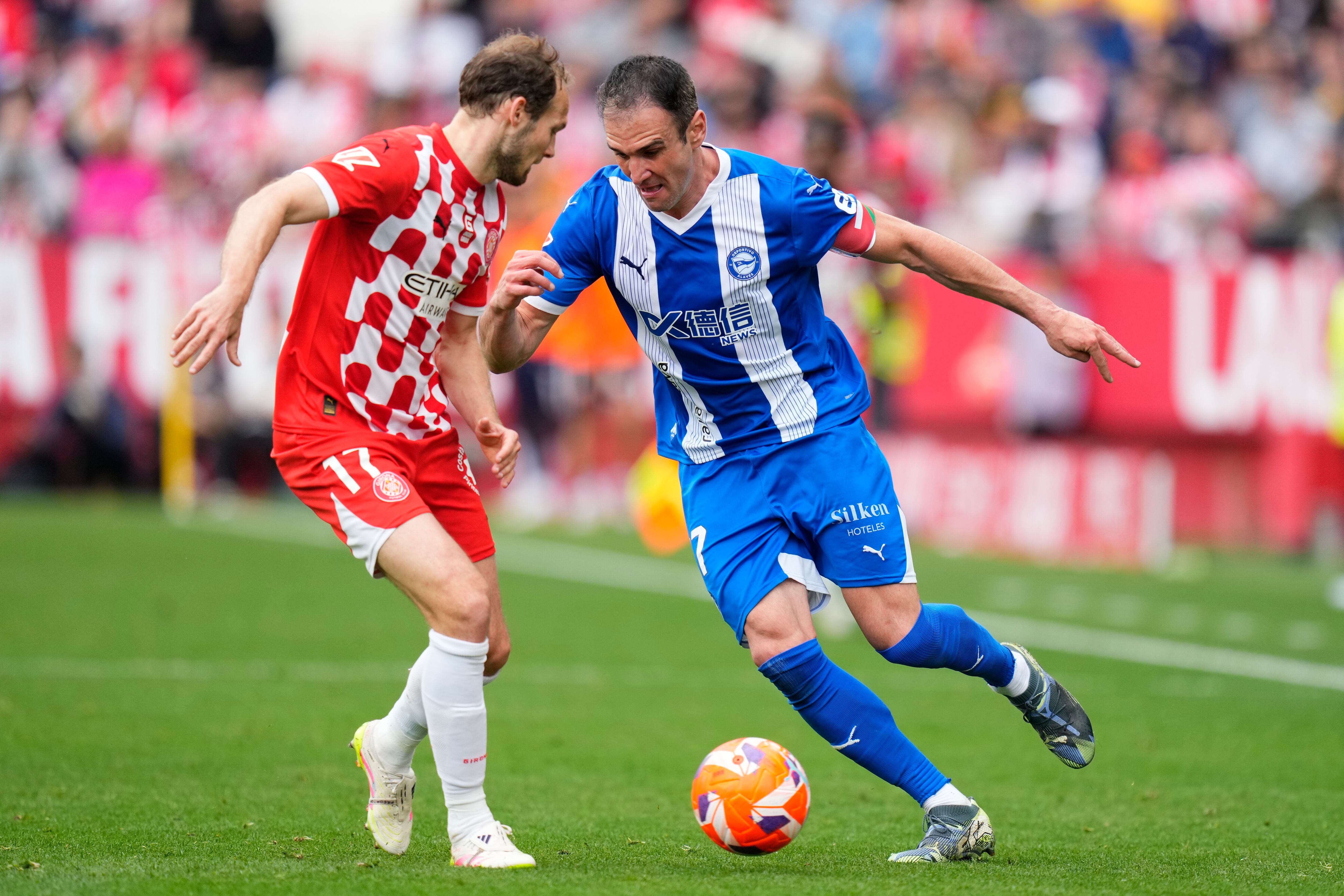GIRONA, 05/04/2025.- El delantero del Deportivo Alavés Kike García (d) pelea un balón con el neerlandés Daley Blind, del Girona durante el partido de LaLiga entre el Girona y el Deportivo Alavés este sábado en el estadio Montilivi en Girona. EFE/ Siu Wu