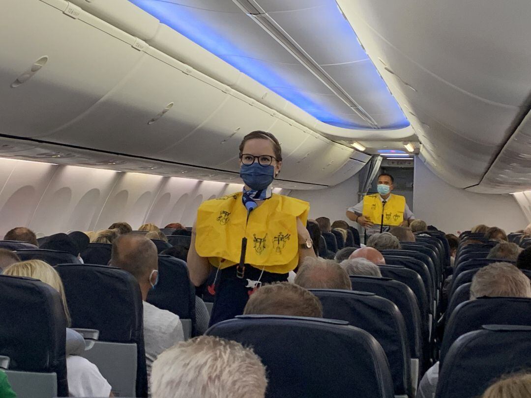 Flight attendants of TUI Fly wear face masks as they give instructions