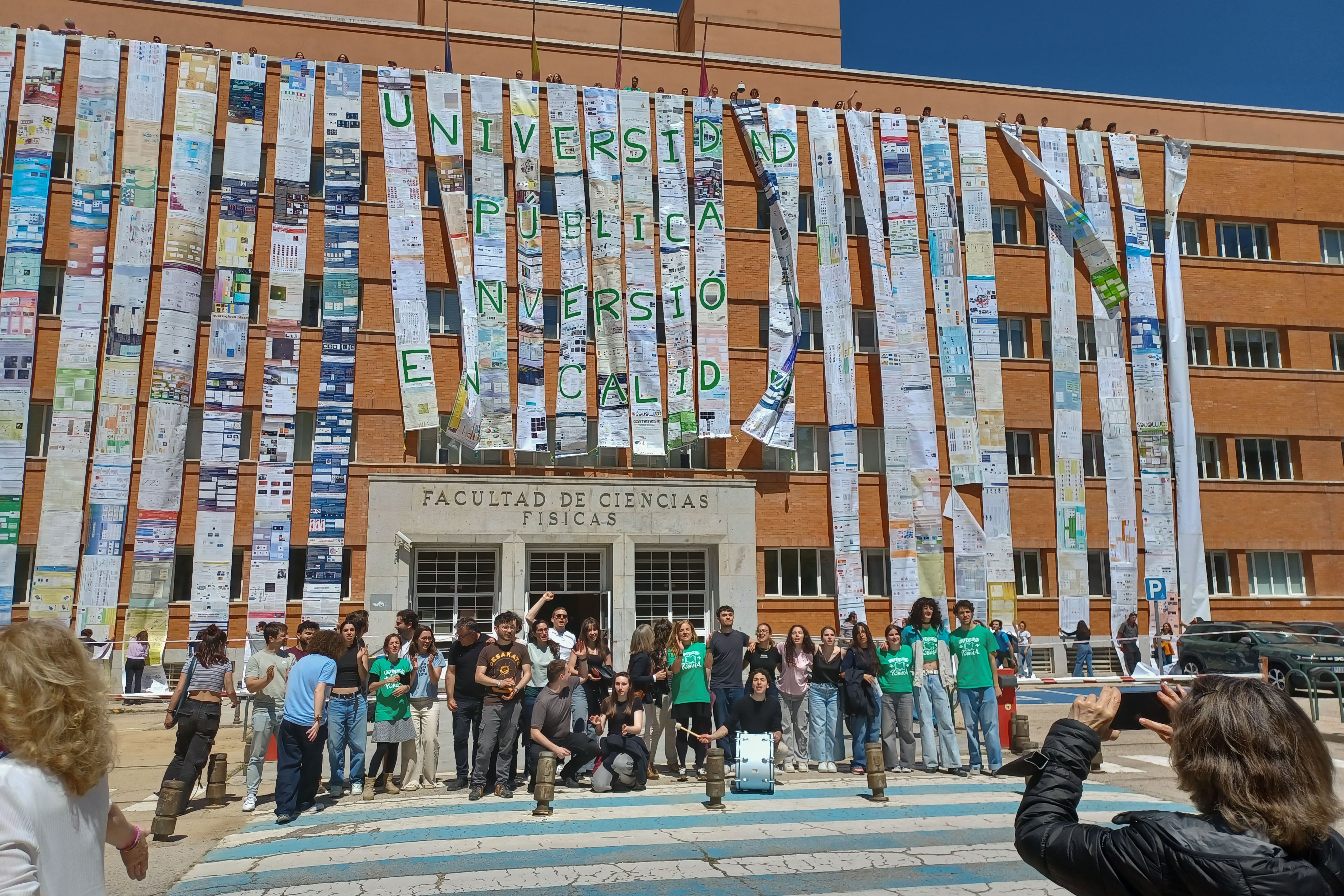Profesores de la Complutense cubren la fachada de la Facultad de Físicas con un gran mural bajo el lema 'Universidad pública, inversión en calidad'.