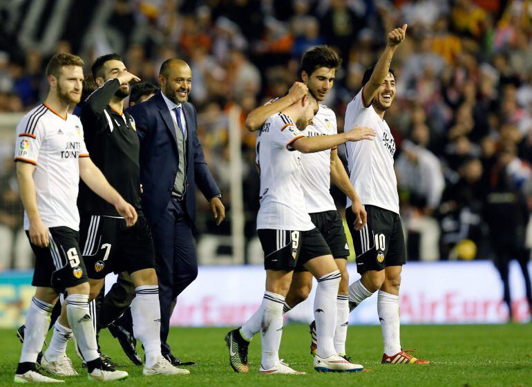 GRA177. VALENCIA, 04/01/2015.- El entrenador portugués del Valencia Nuno Espírito Santo (3i) y sus jugadores celebran la victoria conseguida sobre el Real Madrid, al término del partido de la decimo séptima jornada de Liga de Primera División disputado esta tarde en el estadio de Mestalla. EFE/Juan Carlos Cárdenas