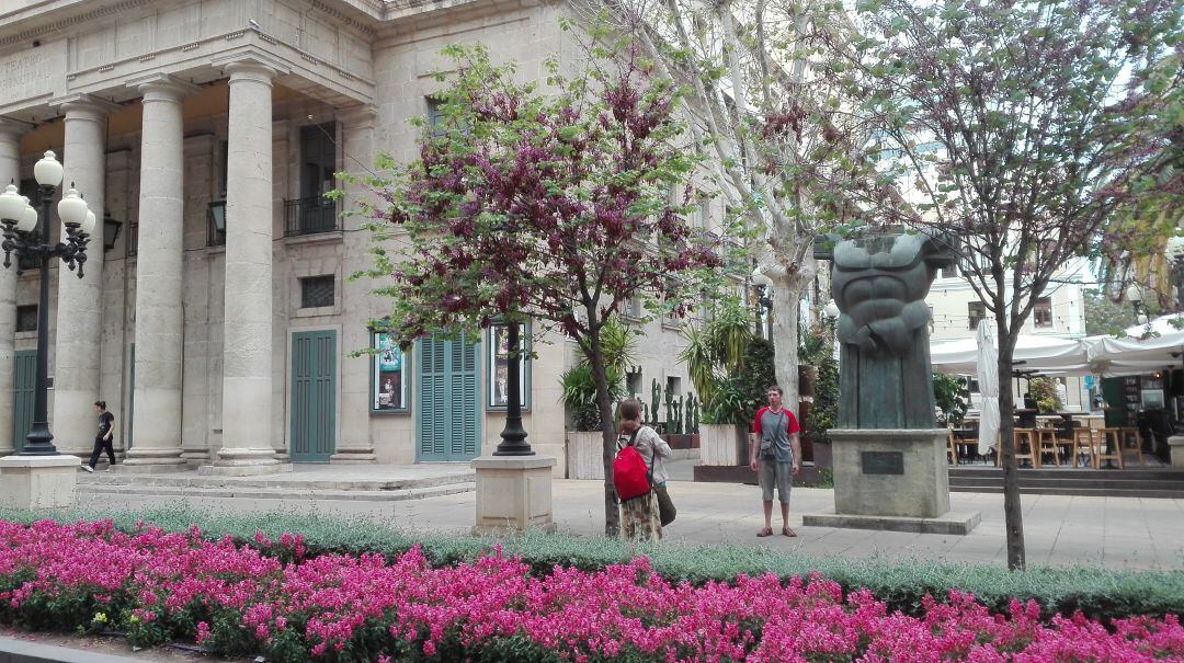 Dos turistas se fotografían frente al Teatro Principal de Alicante.