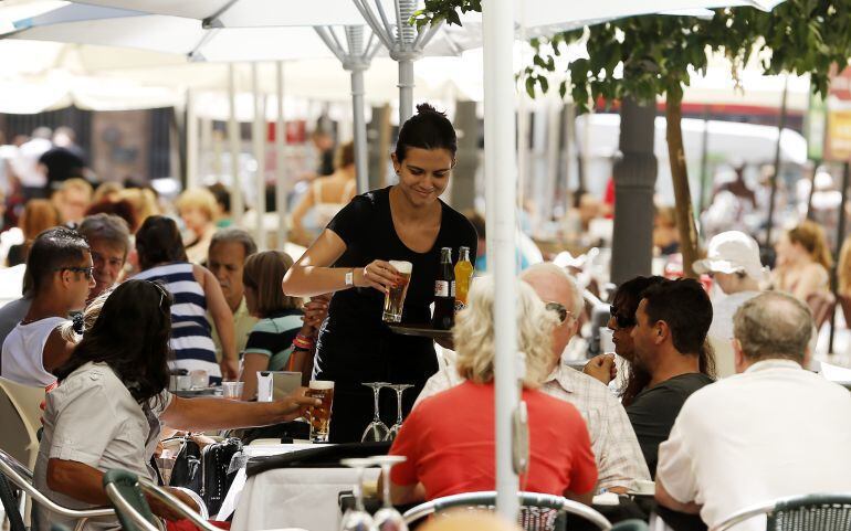 Una camarera atiende una terraza