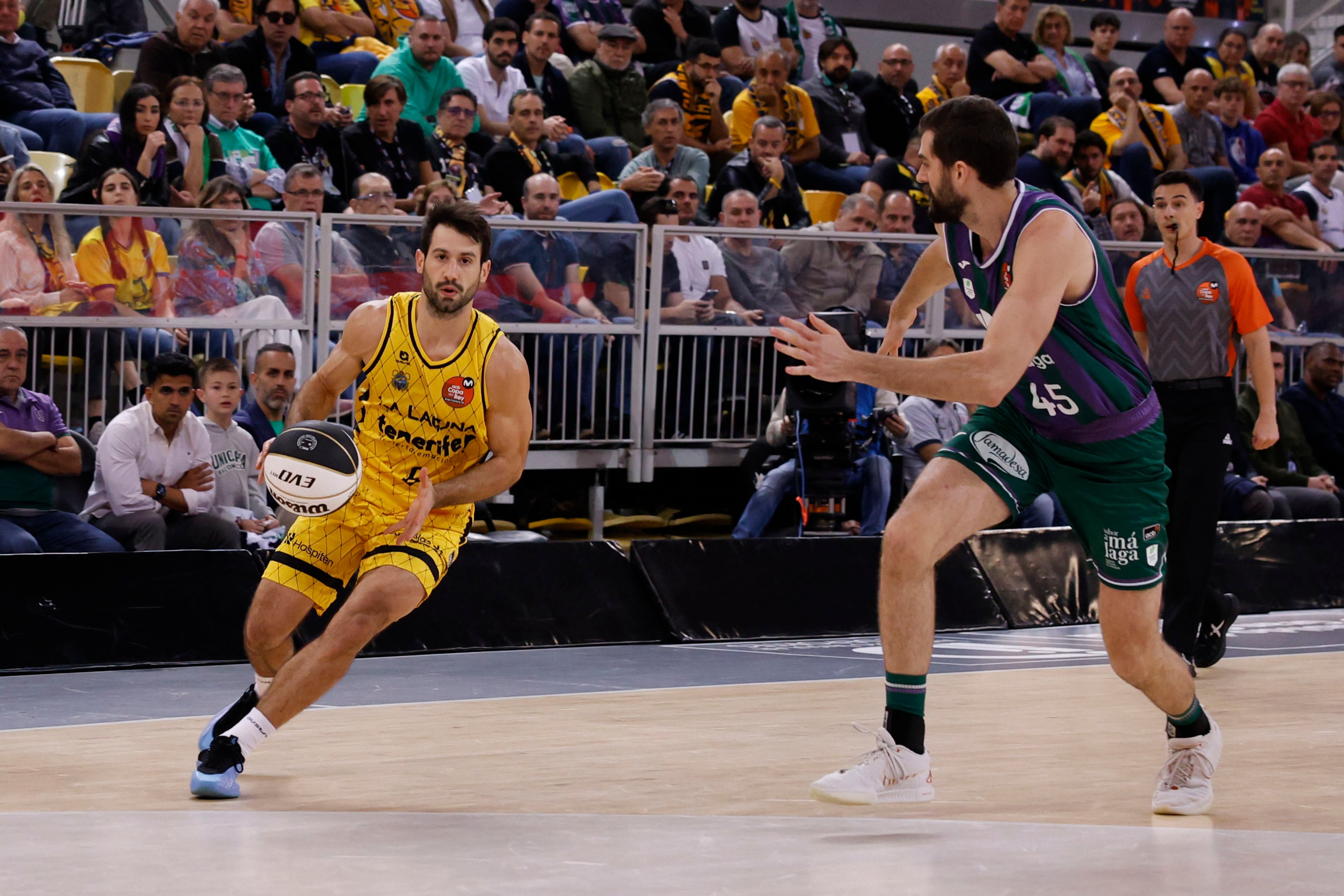 LAS PALMAS DE GRAN CANARIA, 15/02/2025.- El base de La Laguna Tenerife Bruno Fitipaldo (i) avanza con el balón ante David Kravish, de Unicaja, durante el primer partido de semifinales de la Copa del Rey que Unicaja Málaga y La Laguna Tenerife disputan este sábado en el Gran Canaria Arena, en Las Palmas de Gran Canaria. EFE/Elvira Urquijo A.
