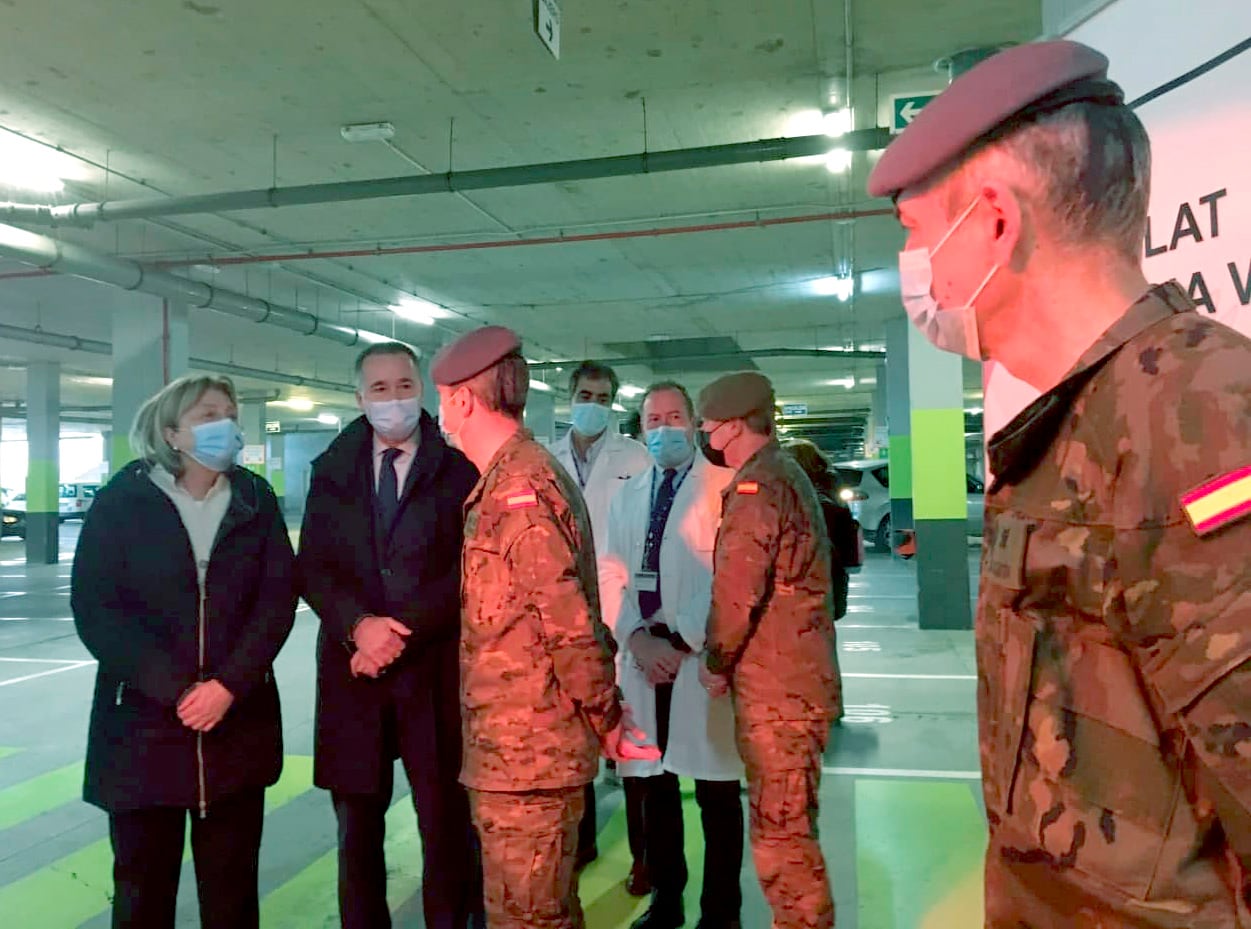 La Delegada del Gobierno, Delia Losa, y el Consejero de Salud, Pablo Fernández, visitando el punto de vacunación atendido por militares en el aparcamiento del HUCA