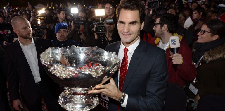 Roger Federer, jugador del equipo suizo de Copa Davis, sostiene el trofeo de la Copa Davis mientras saluda a los aficionados durante una ceremonia de bienvenida al equipo en Lausana, Suiza, hoy, lunes 24 de noviembre de 2014. Suiza ganó ayer su primera Co