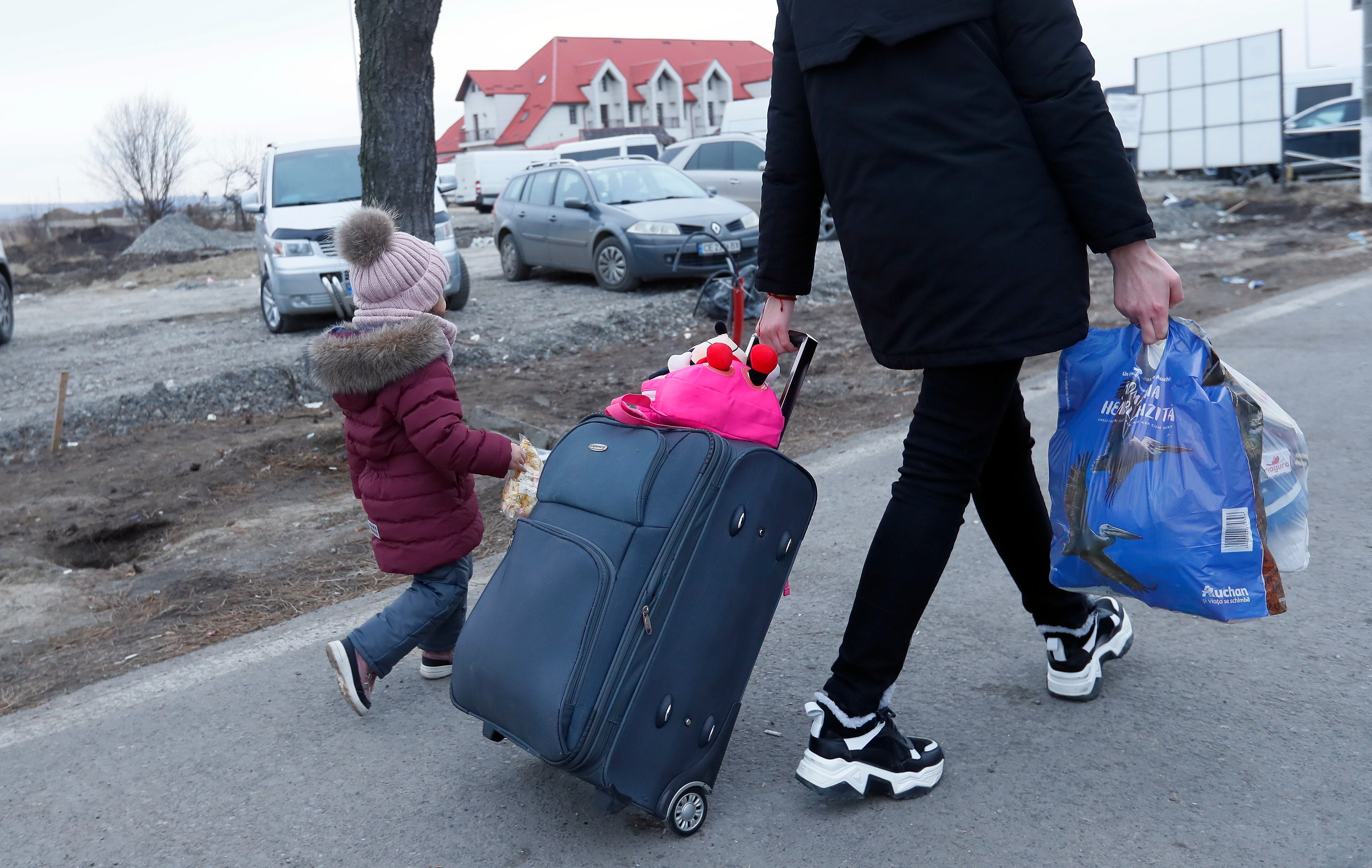 -FOTODELDÍA- EA6479. SIRET, 26/02/2022.- Una familia ucraniana atraviesa la frontera entre Rumanía y Ucrania, este sábado 26 de Febrero, en Siret, Rumania. Las autoridades rumanas han decidido hacer una excepción de las cuarentenas por coronavirus para aquellos refugiados que entren al país procedentes de Ucrania. EFE/EPA/ROBERT GHEMENT