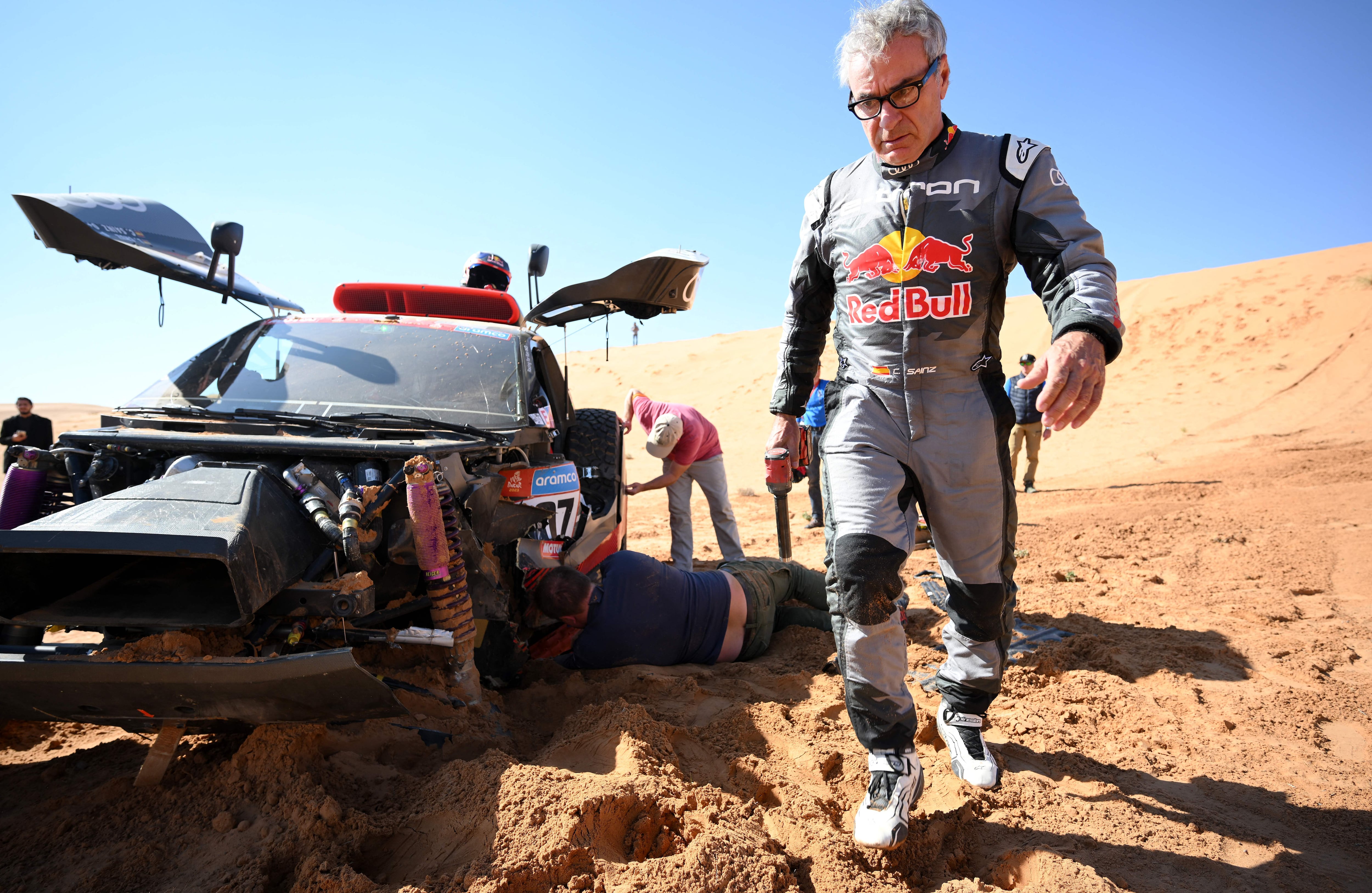 Carlos Sainz intenta reparar su coche en la sexta etapa del Dakar