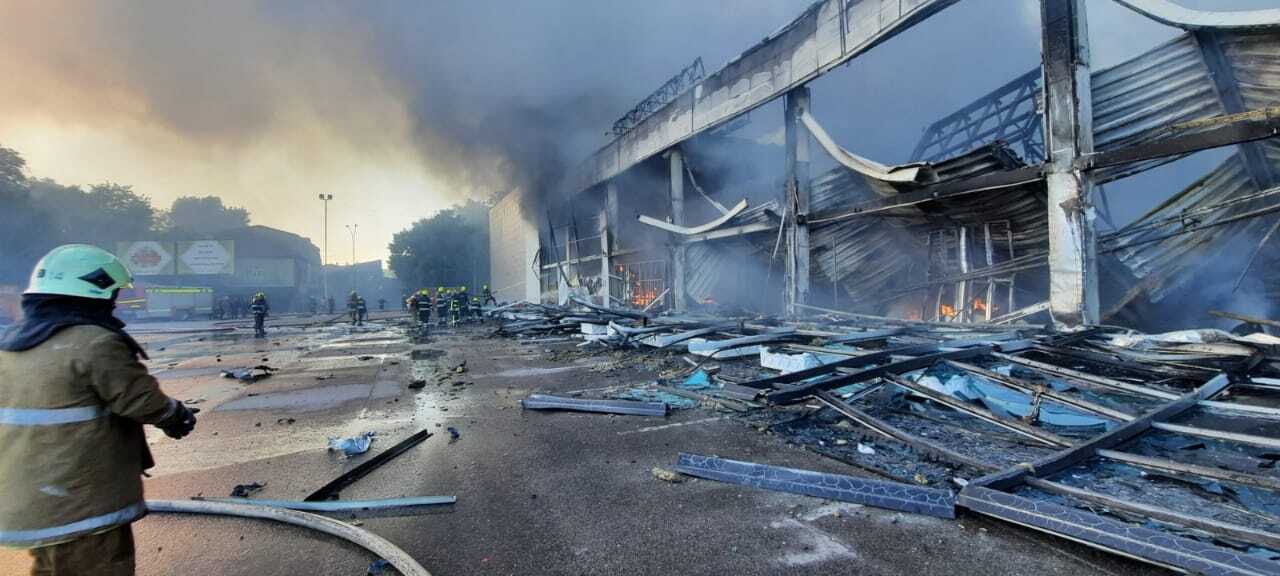 Los bomberos apagan el fuego en el centro comercial tras el ataque ruso. 