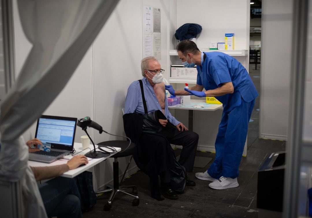 Una sanitaria vacuna a un hombre en el circuito de vacunación de Fira de Barcelona