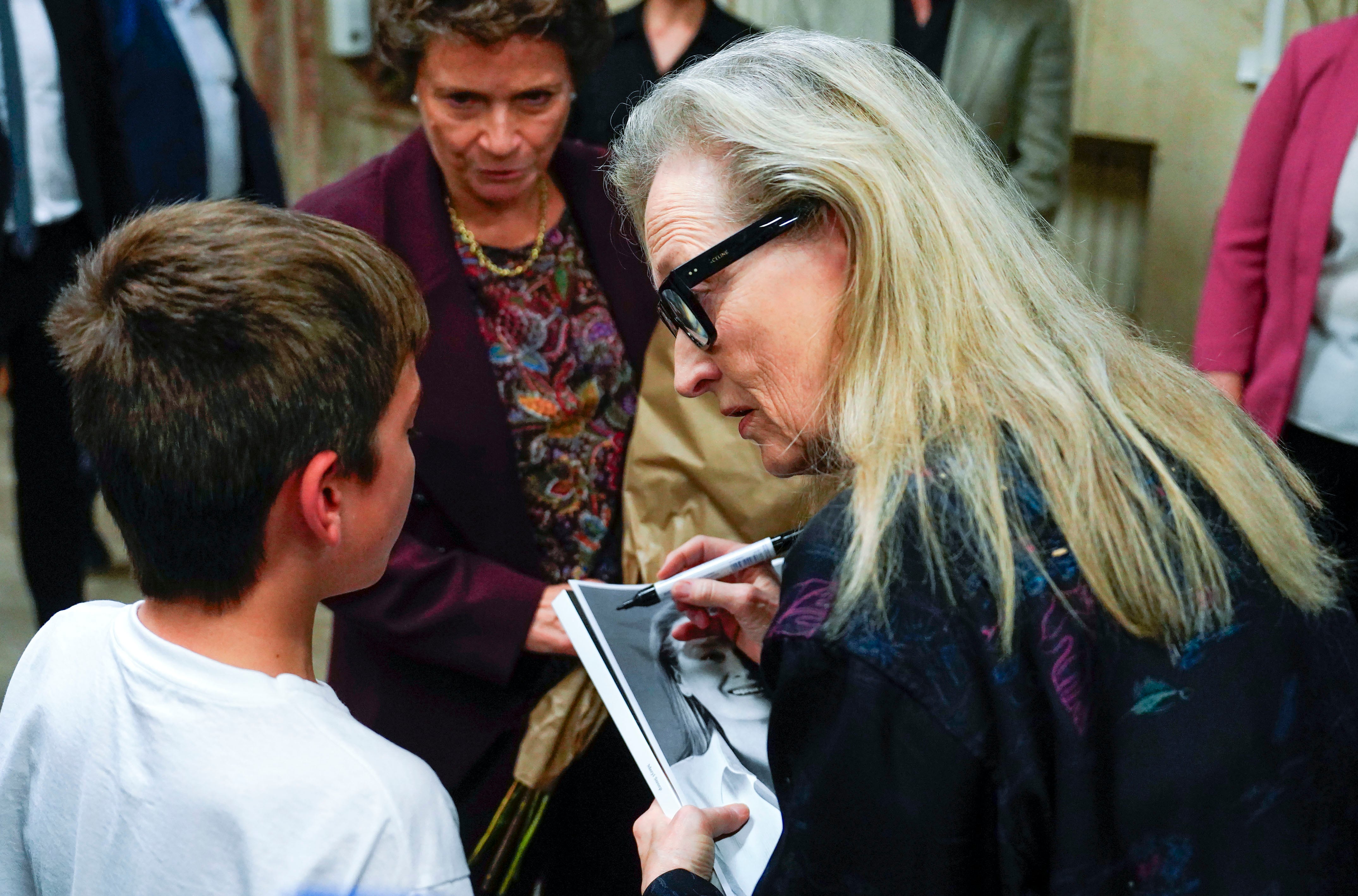 La actriz estadounidense Meryl Streep firma una foto a un joven fan en un encuentro con estudiantes de la Escuela Superior de Arte Dramático del Principado.