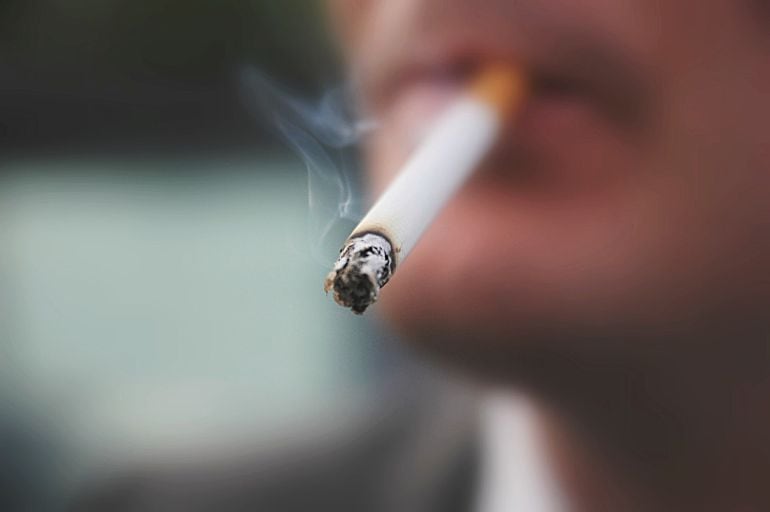 Primer plano de un joven fumando un cigarrillo