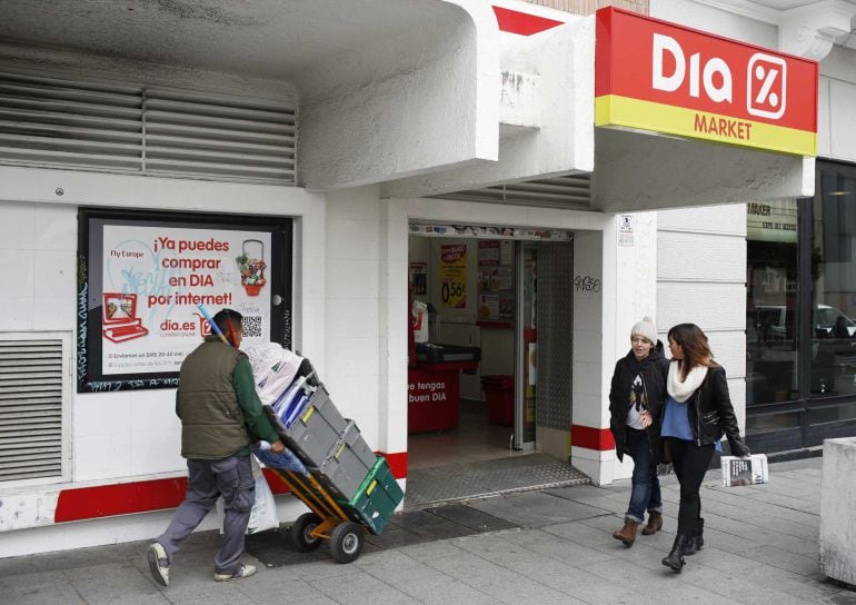 People walk outside a DIA supermarket in central Madrid February 23, 2015. Spanish discounter DIA posted a 68 percent rise in full-year net profit to 329.2 million euros ($374.53 million) as its purchase of supermarket peer El Arbol gave it a tax lift off