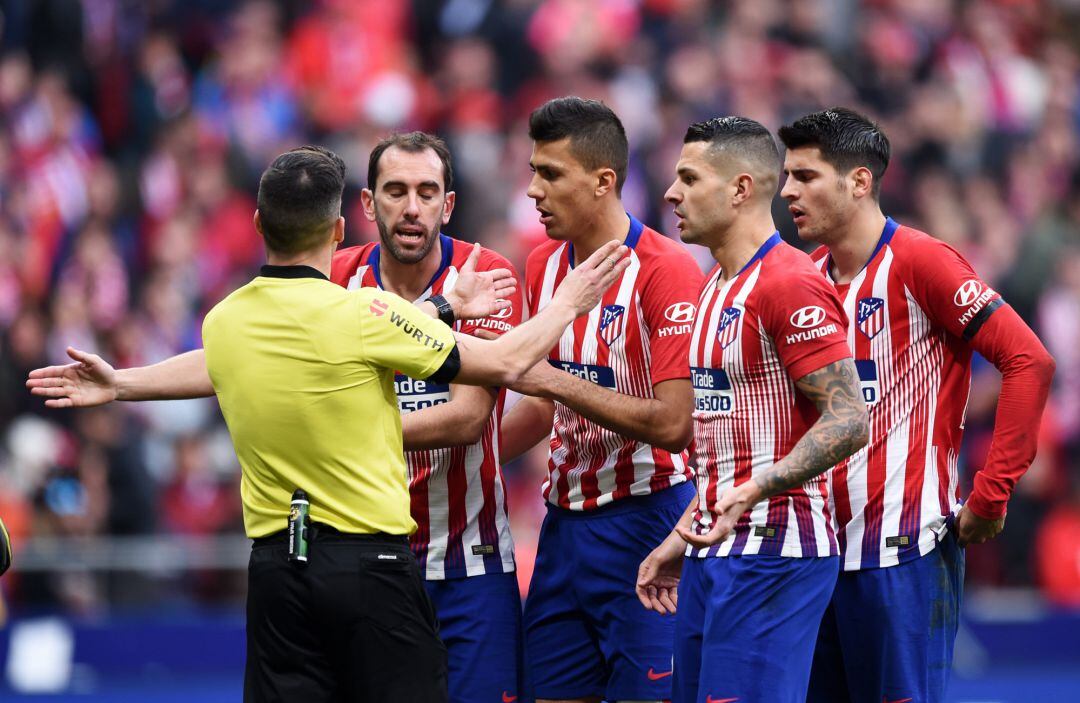 Los jugadores del Atlético protestan una acción en el derbi madrileño