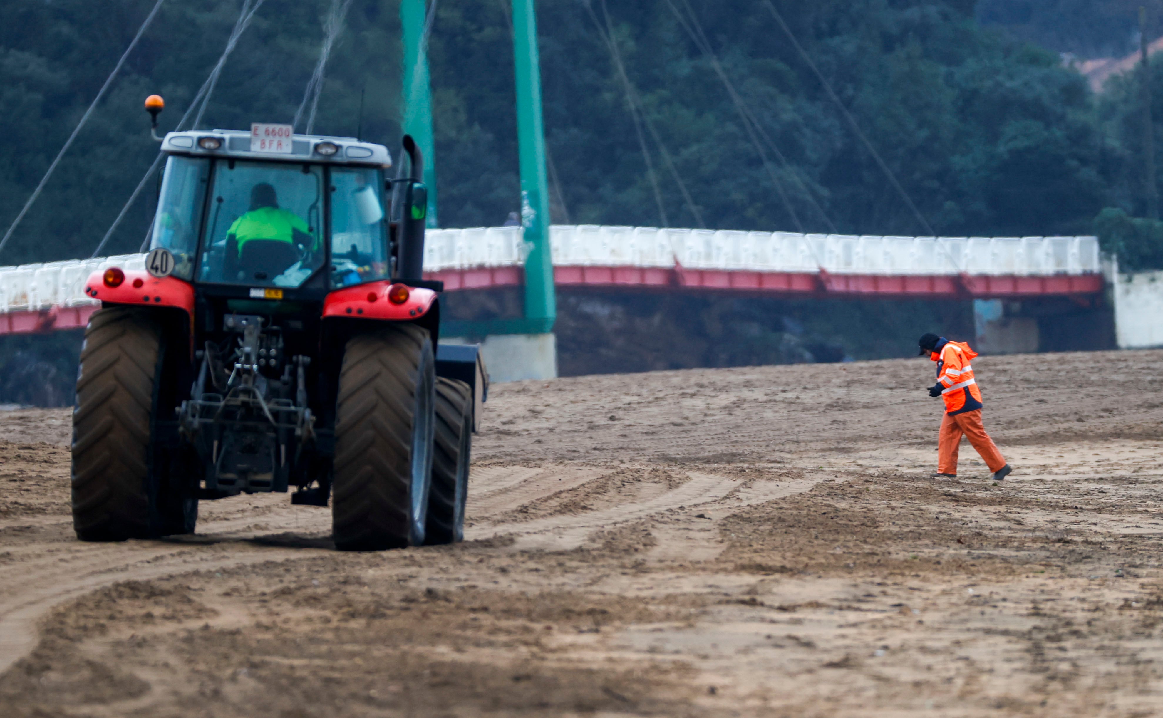 Personal de la diputación vizcaína, junto a un tractor de limpieza buscan pellets en la playa de La Arena