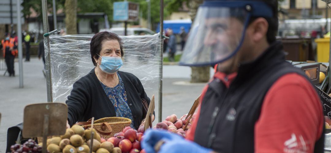 Una anciana realiza la compra en un mercadillo.