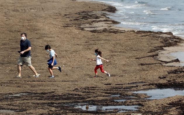 Un padre con sus dos hijos, hoy en la Playa de la Malvarrosa de València