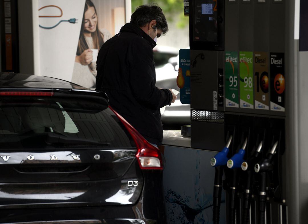 Un hombre echa gasolina a su coche en una gasolinera.