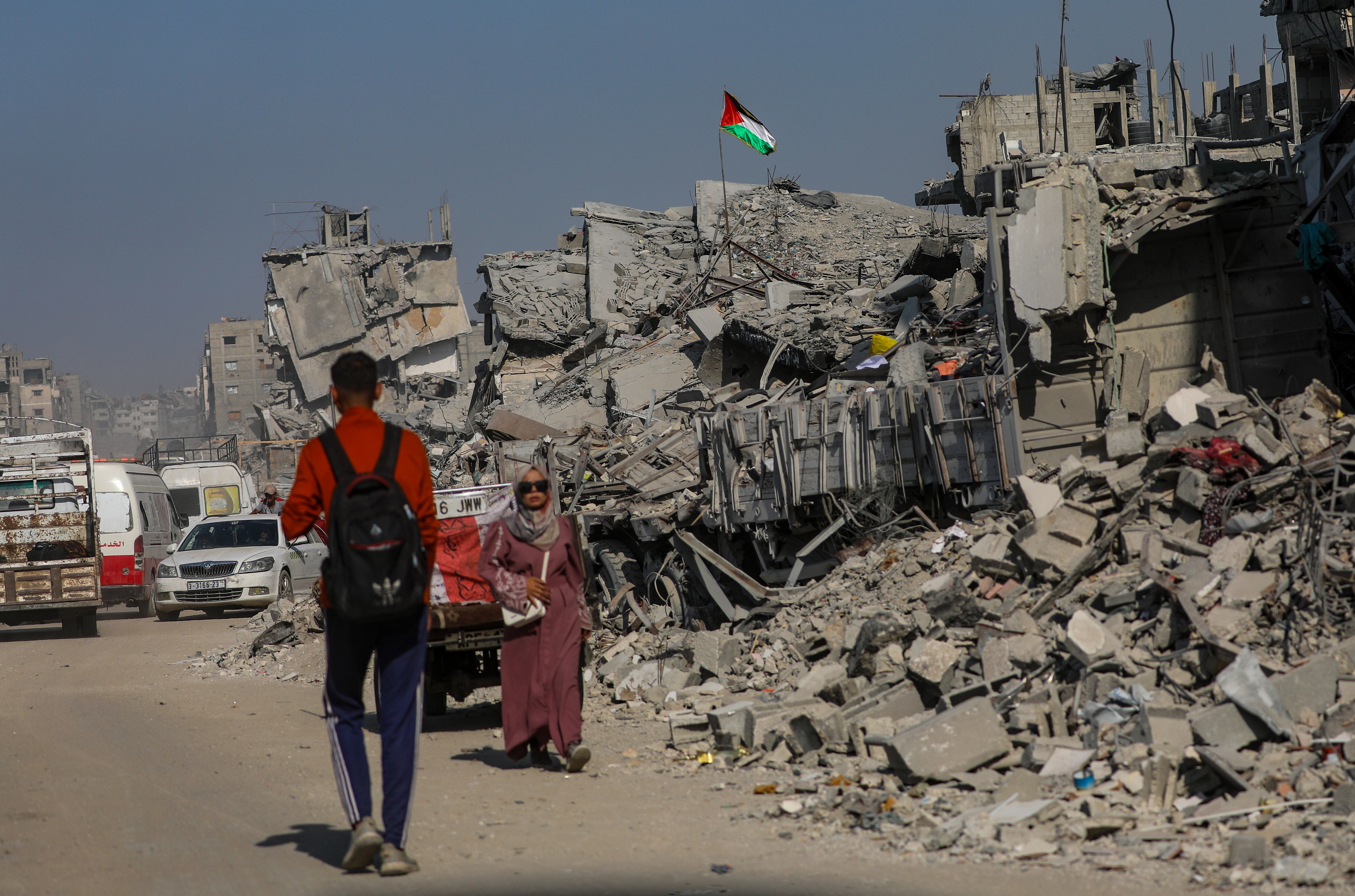 Palestinos se desplazan entre los escombros de edificios destruidos en el barrio de Sheikh Redwan, gravemente dañado, de la ciudad de Gaza, el 23 de octubre de 2025.