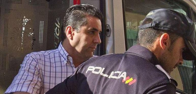 Imagen del director saliendo del furgón policial