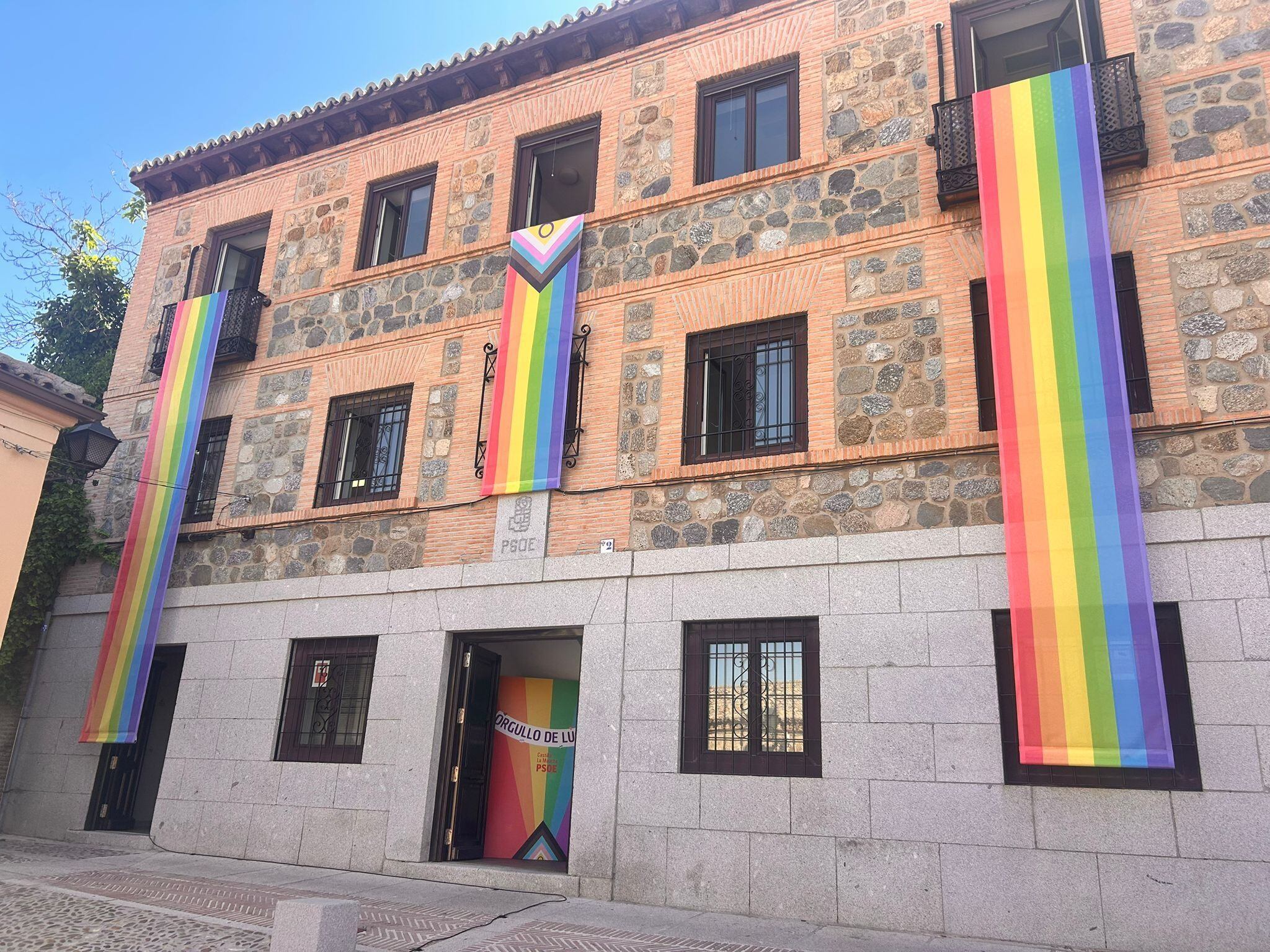 Tres banderas LGTBI en la fachada de la sede del PSOE