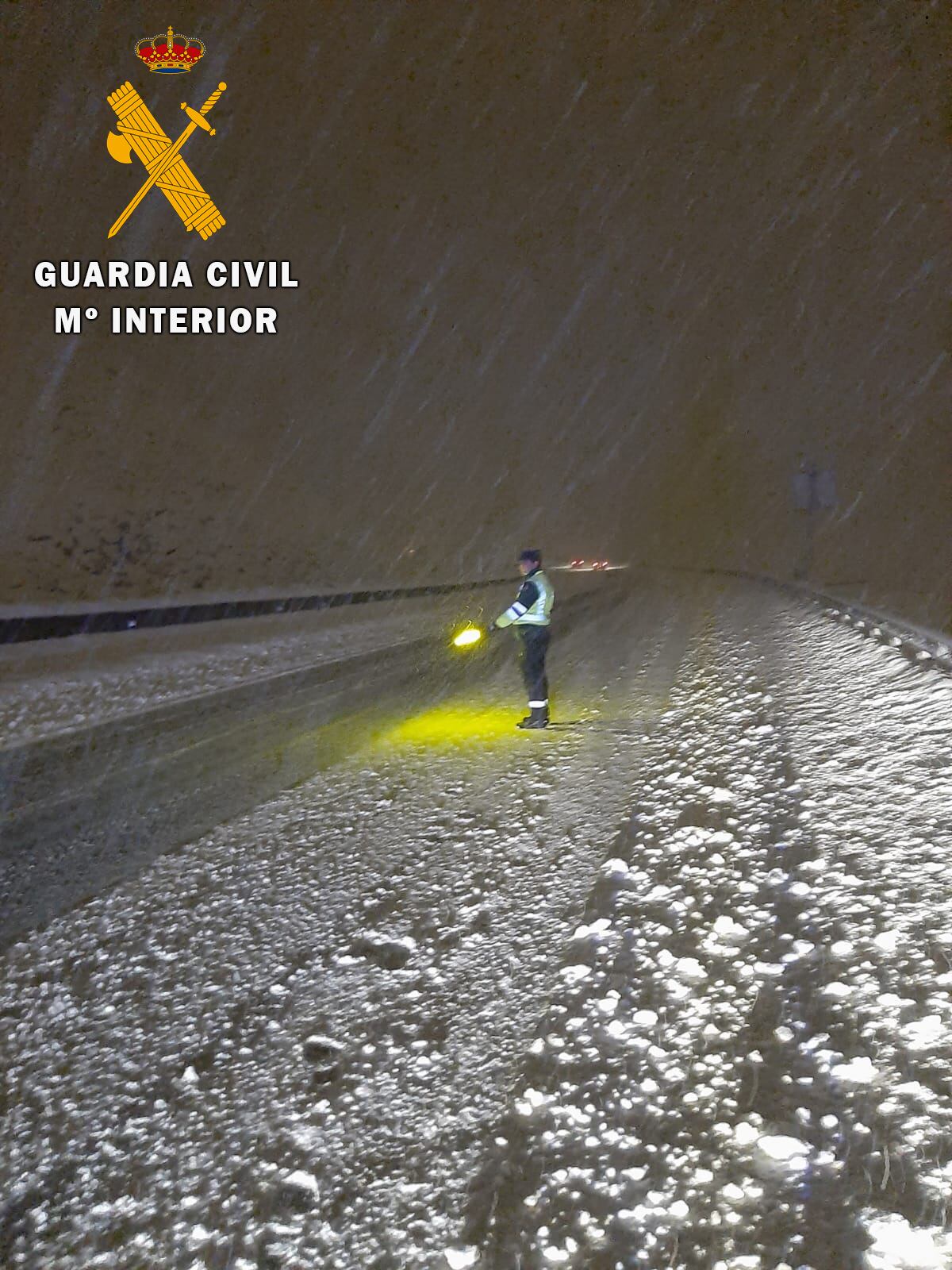 Un agente de la Guardia Civil de Tráfico señaliza la vía de salida para los vehículos atrapados por la nieve en Lantueno.