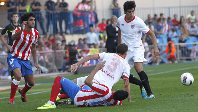 El centrocampista del Atlético de Madrid José Antonio Reyes cae al césped tras disputar la pelota con el defensa del Sevilla FC Fernando Navarro durante el partido correspondiente a la séptima jornada de la Liga en Primera División