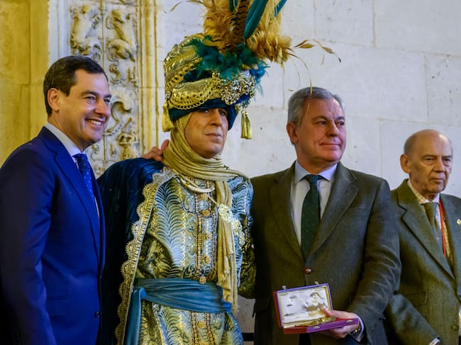 SEVILLA, 04/01/2026.- El Heraldo de los Reyes Magos de Sevilla, que este año ha sido encarnado por el empresario sevillano Sergio Garcia (c), tras recibir las llaves de la Ciudad de manos del alcalde, José Luis Sanz (cd), acompañado por el Presidente de la Junta de Andalucía, Juanma Moreno (ci), este domingo en el ayuntamiento de Sevilla. EFE/ Raúl Caro.