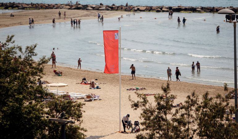 La bandera roja, que alerta de la presencia de carabelas portuguesas, ondea en una playa de Alicante, en una imagen de archivo 