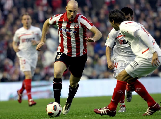 Gaizka Toquero conduce el balón presionado por los jugadores del Sevilla CF Gary Medel y Julien Escudé