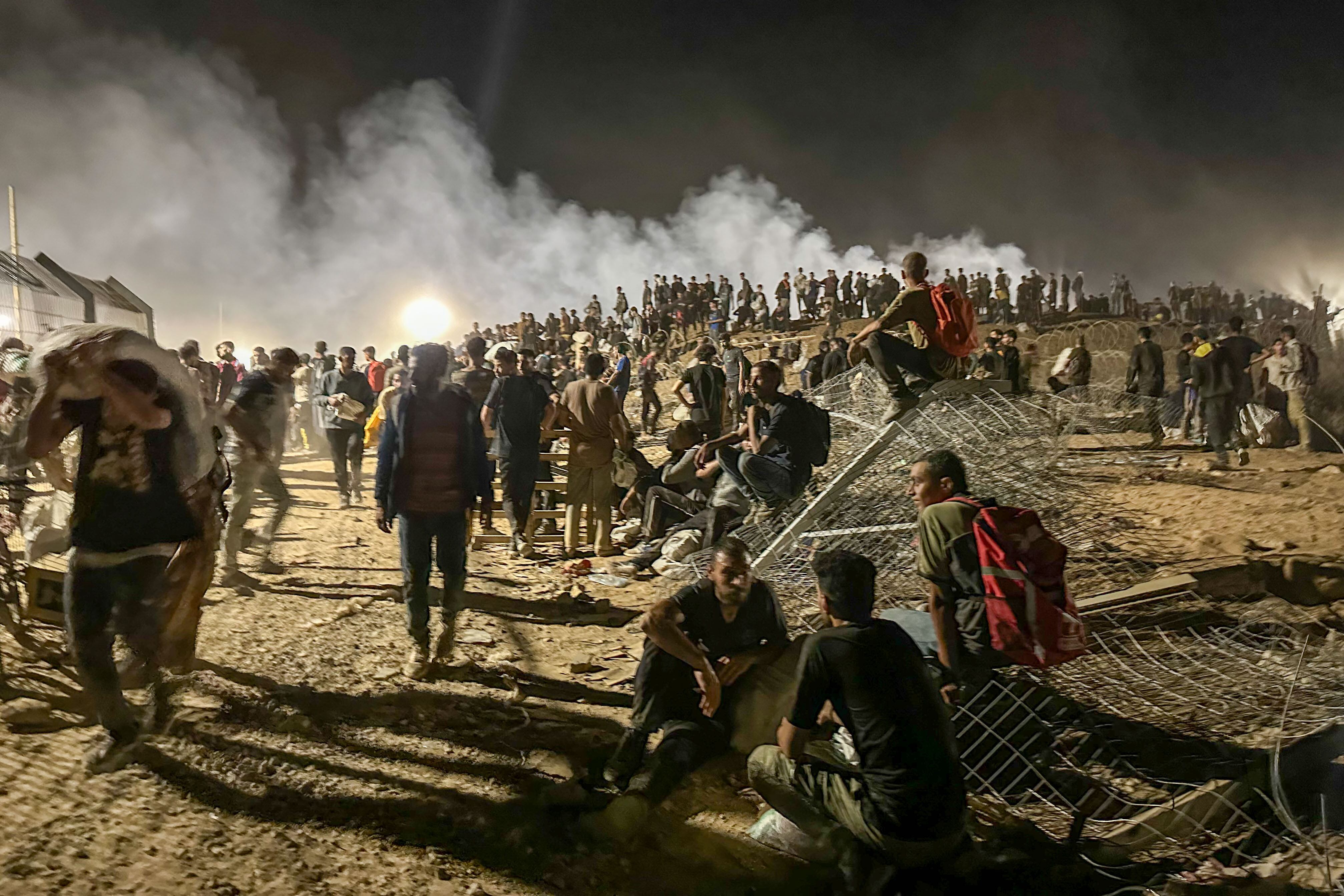 Un único acceso con rejas metálicas lleva a un descampado rodeado de barricadas de arena con neumáticos ardiendo. 