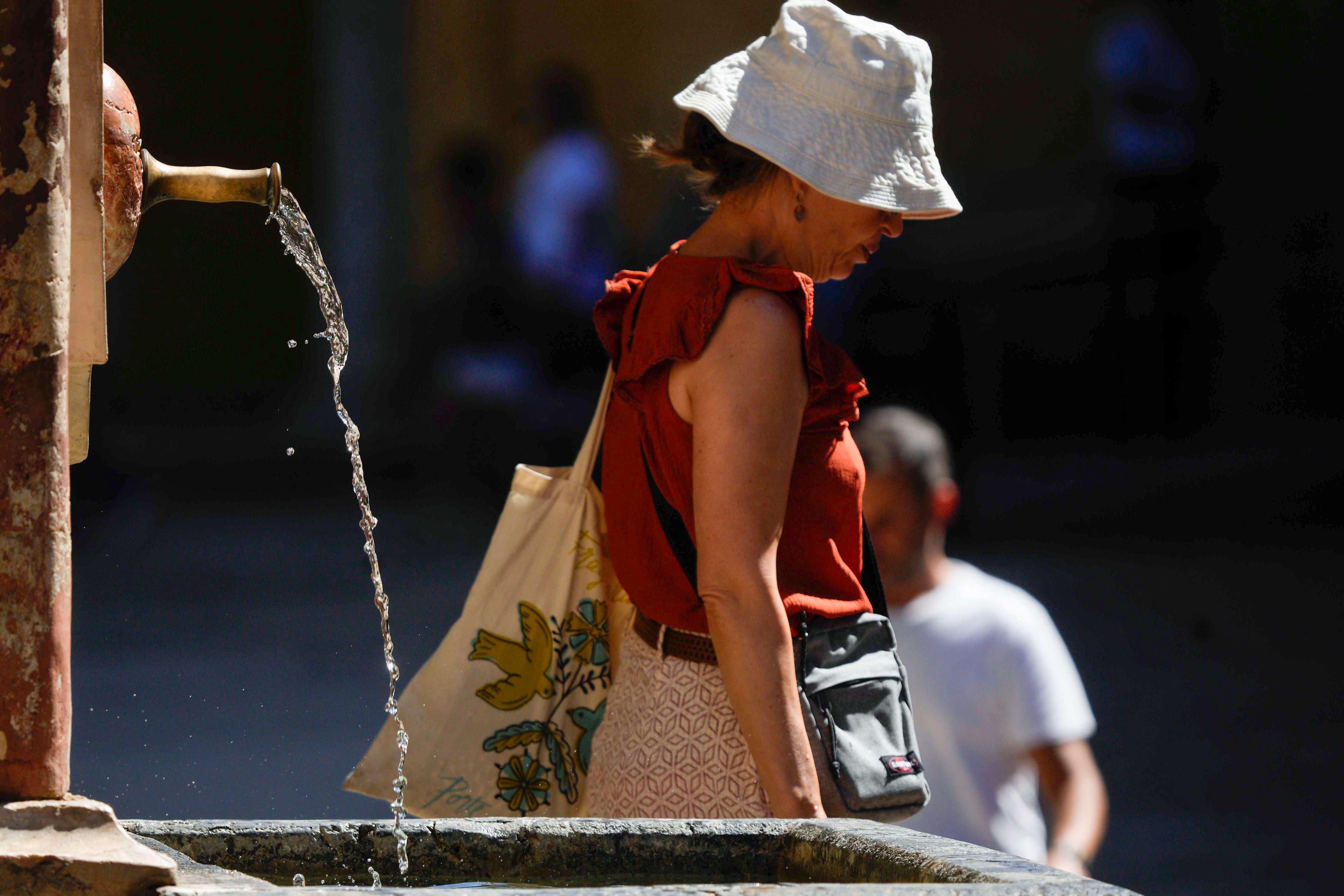 Una mujer pasa junto a una fuente de la Mezquita-Catedral de Córdoba