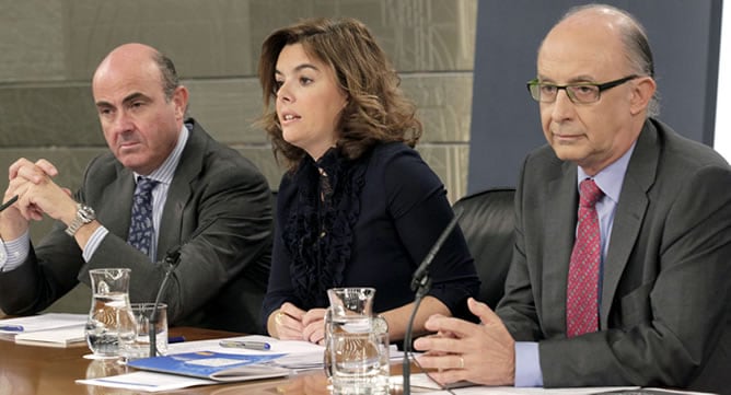 La vicepresidenta del Gobierno, Soraya Sáenz de Santamaría, y los ministros de Hacienda y Administraciones Públicas, Cristóbal Montoro (dcha), y Economía, Luis de Guindos, durante la rueda de prensa del Consejo de Ministros en el que han detallado los Pre