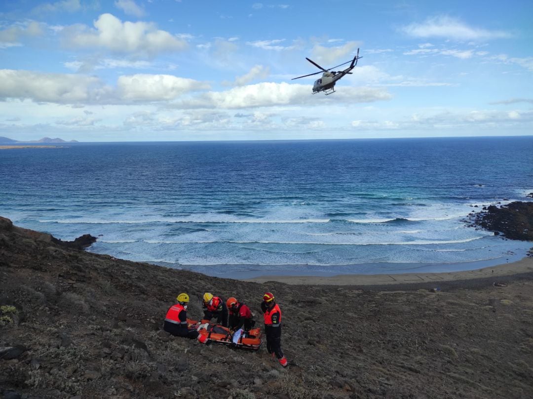 Los servicios de emergencia aseguran al herido antes de ser izado por el helicóptero.